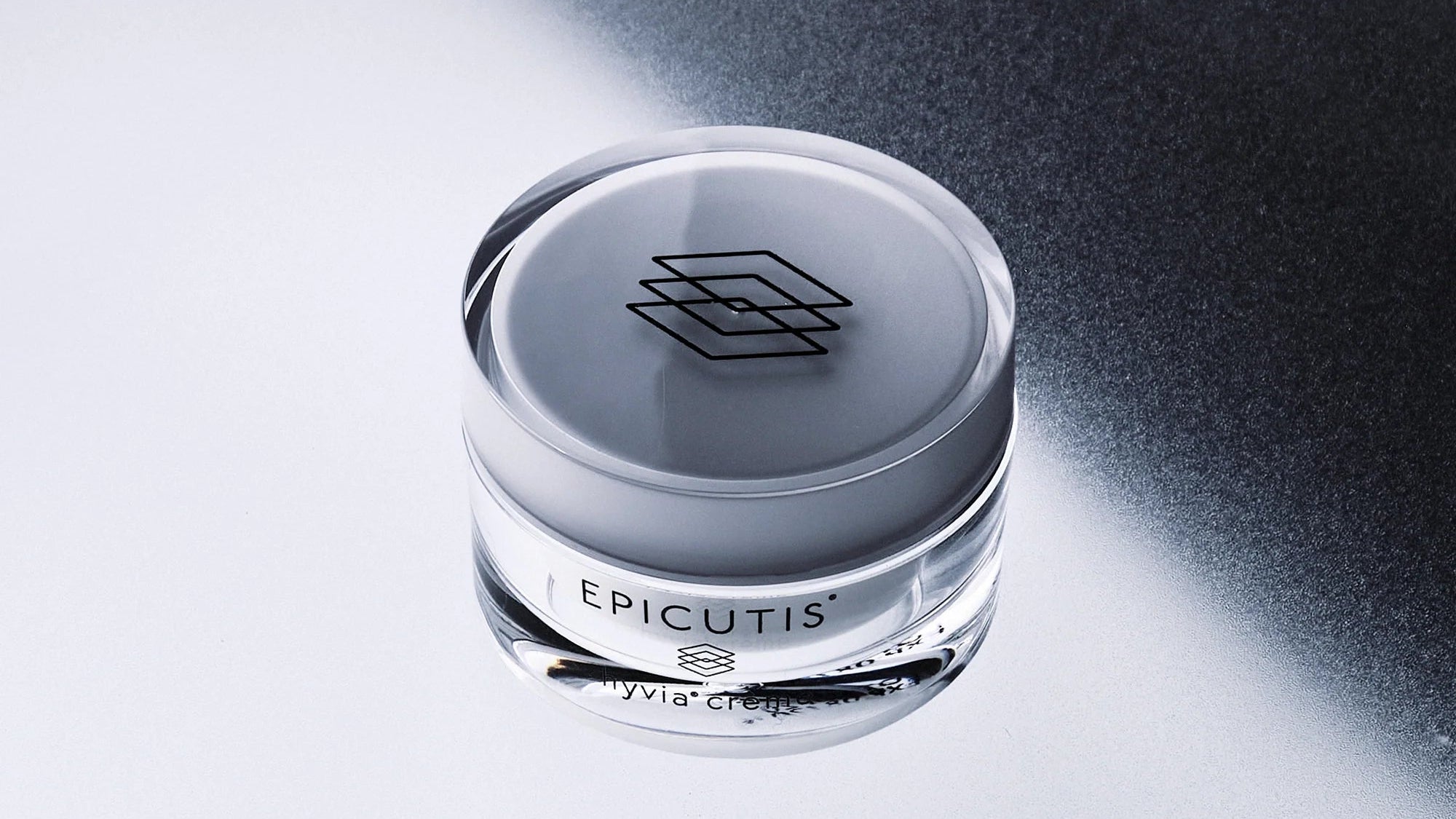 Epicutis cream jar on a reflective surface with a black background