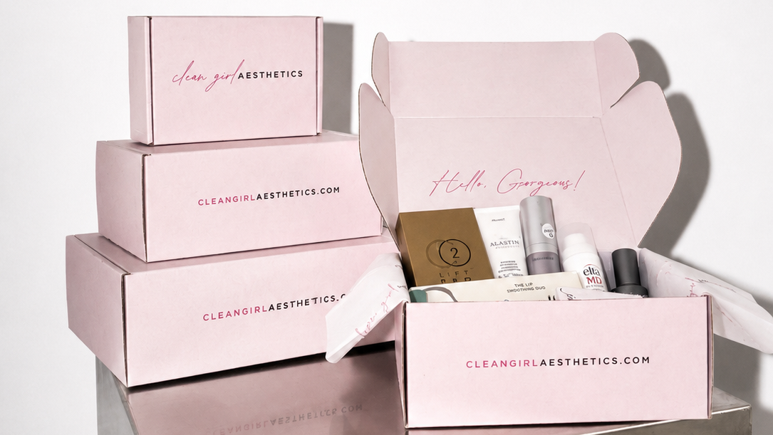 Set of pink boxes with skincare products on a metallic surface