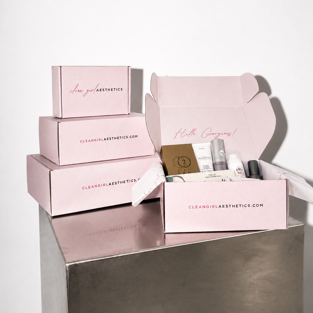 Set of pink boxes with skincare products on a metallic surface
