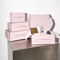 Set of pink boxes with skincare products on a metallic surface